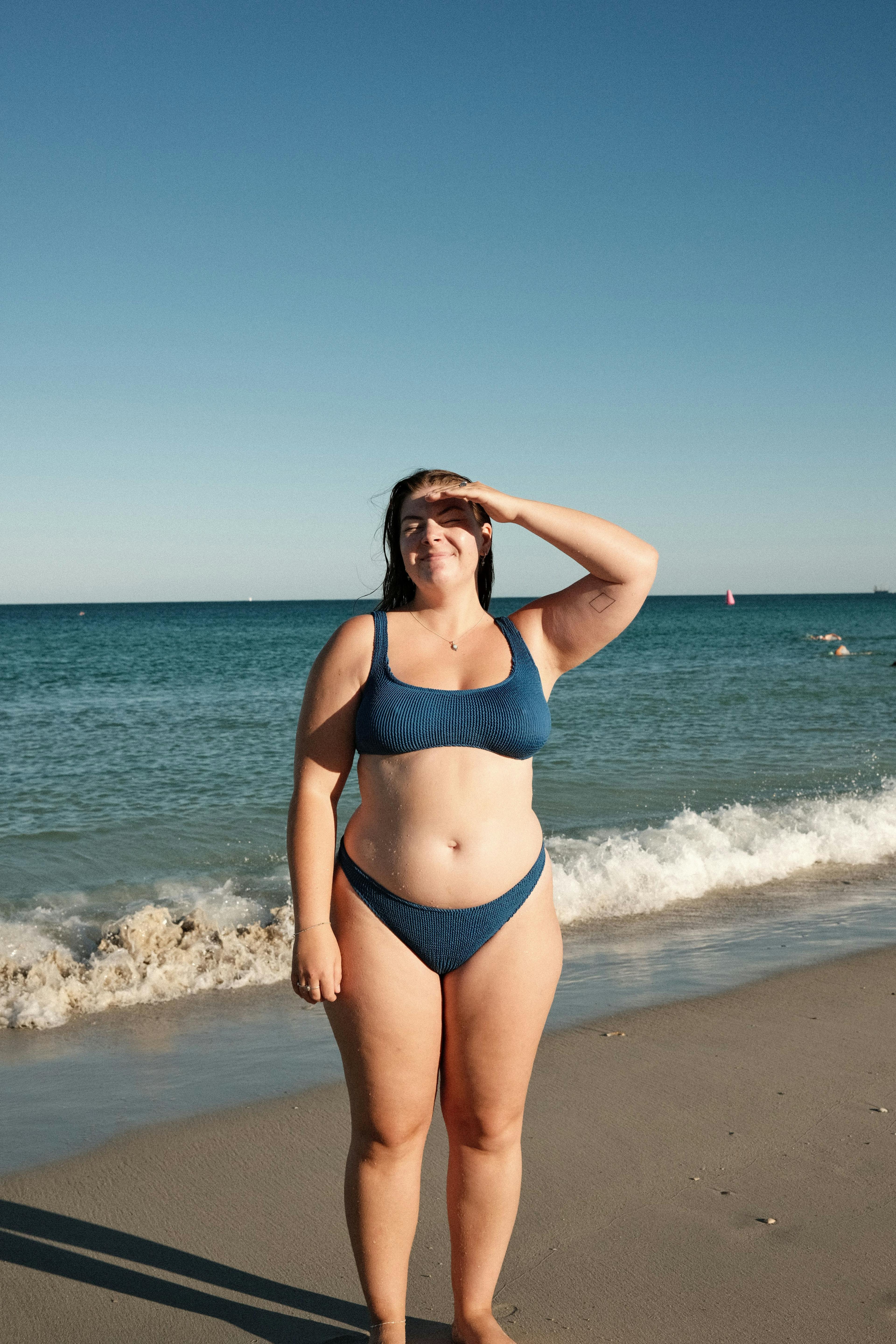 Tara Jeisman at the beach wearing a blue bikini