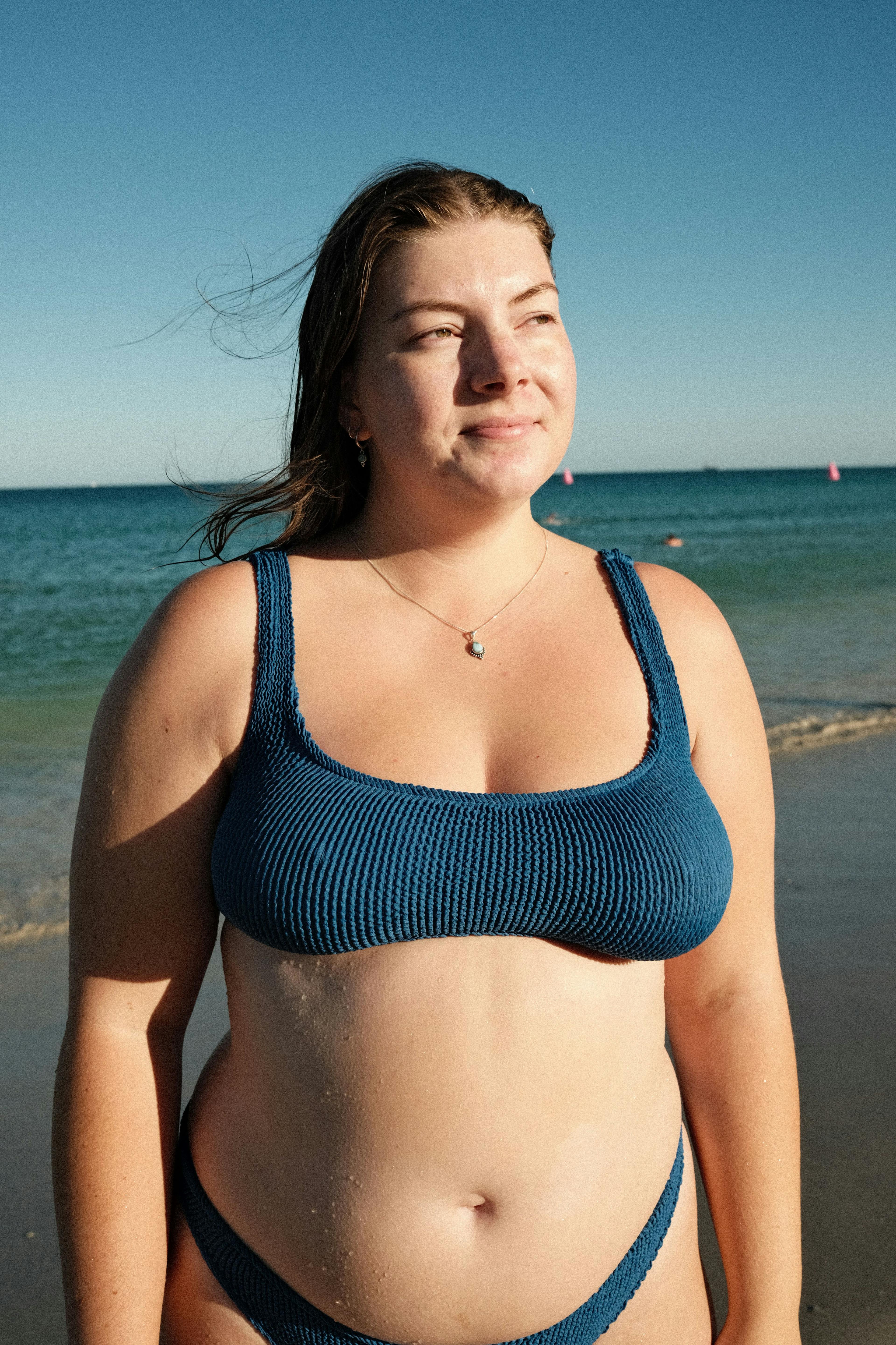 Tara wearing blue bikini by the ocean